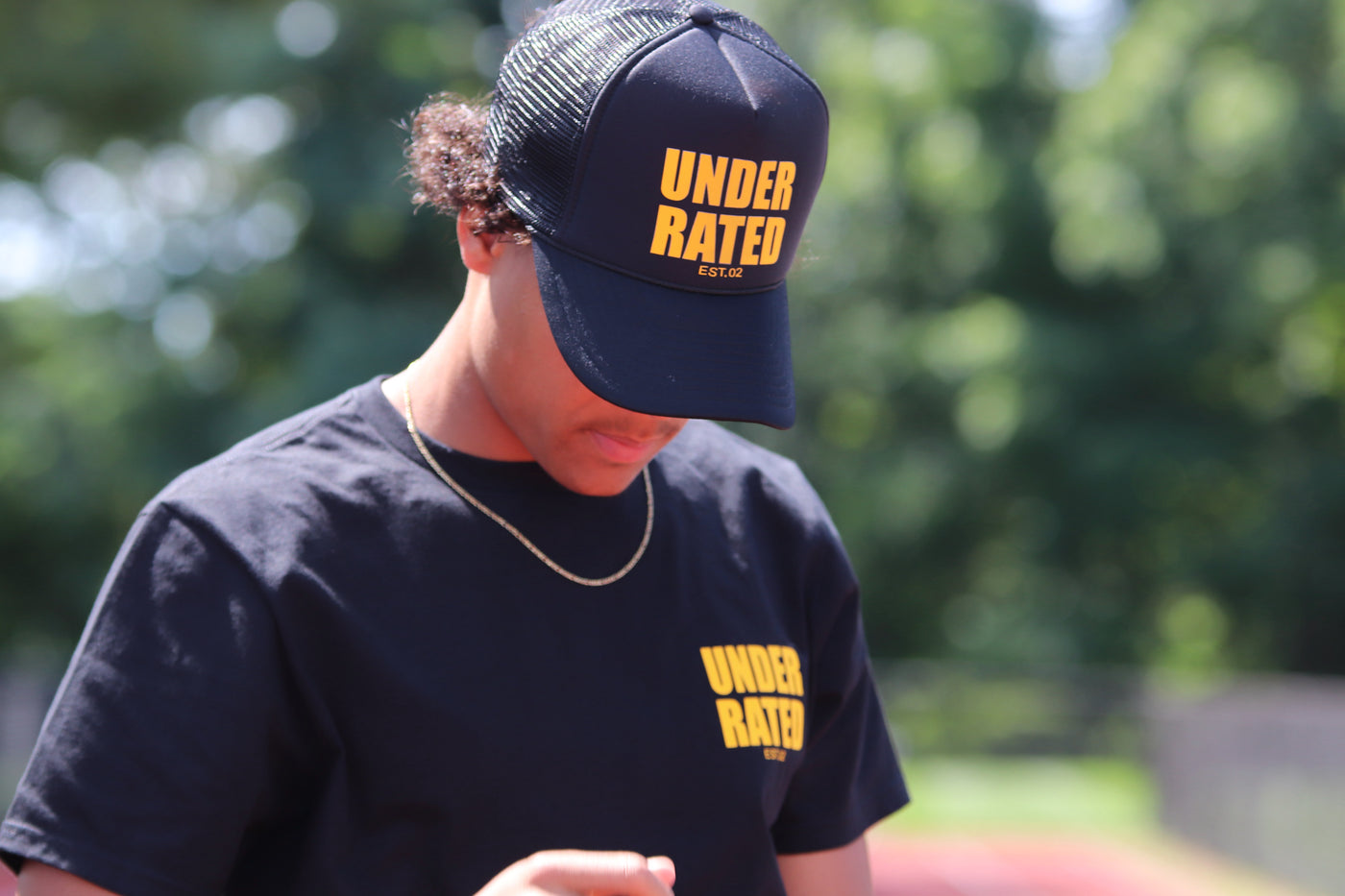 BLACK UNDERRATED TRUCKER HAT WITH YELLOW FONT
