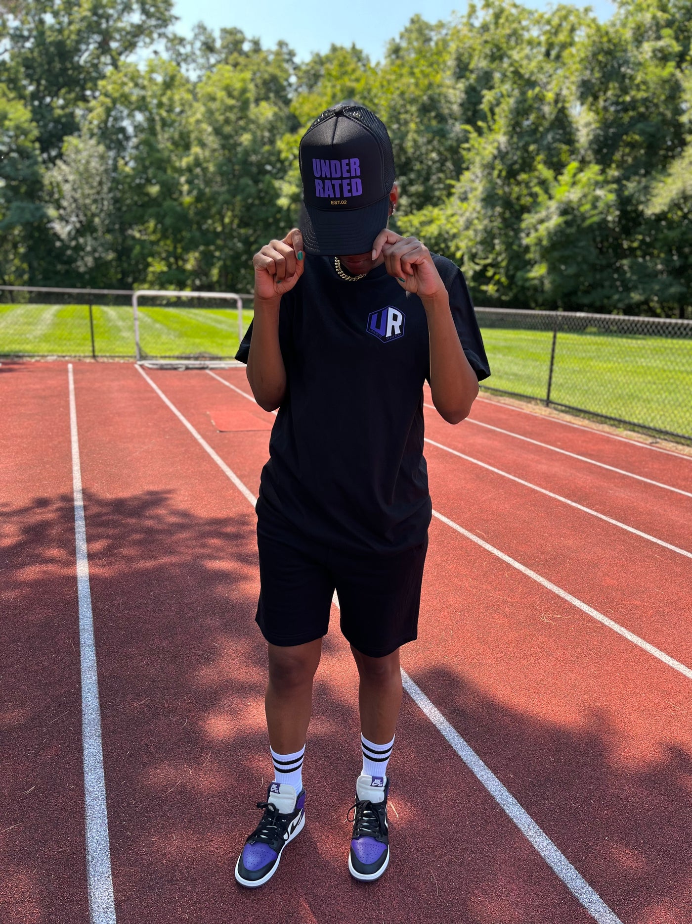 BLACK UNDERRATED TRUCKER HAT WITH PURPLE FONT